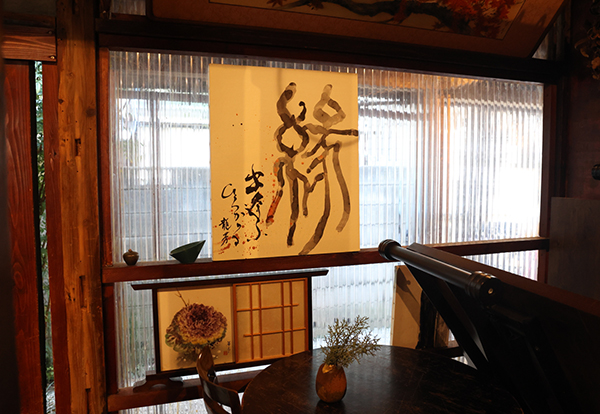 米本さんは「なすご龍芳」という名前で、書家・アートセラピストとしても活躍中。rojicoya内にも米本さんの作品が飾られている